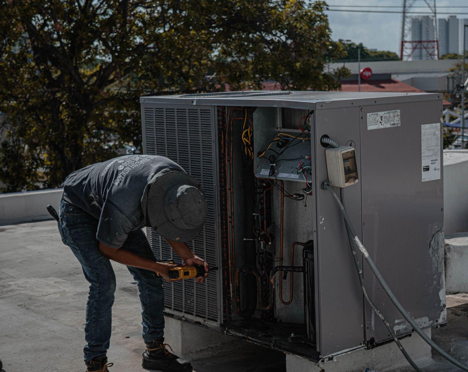 Técnico da Climatize realizando manutenção em unidade de ar condicionado
